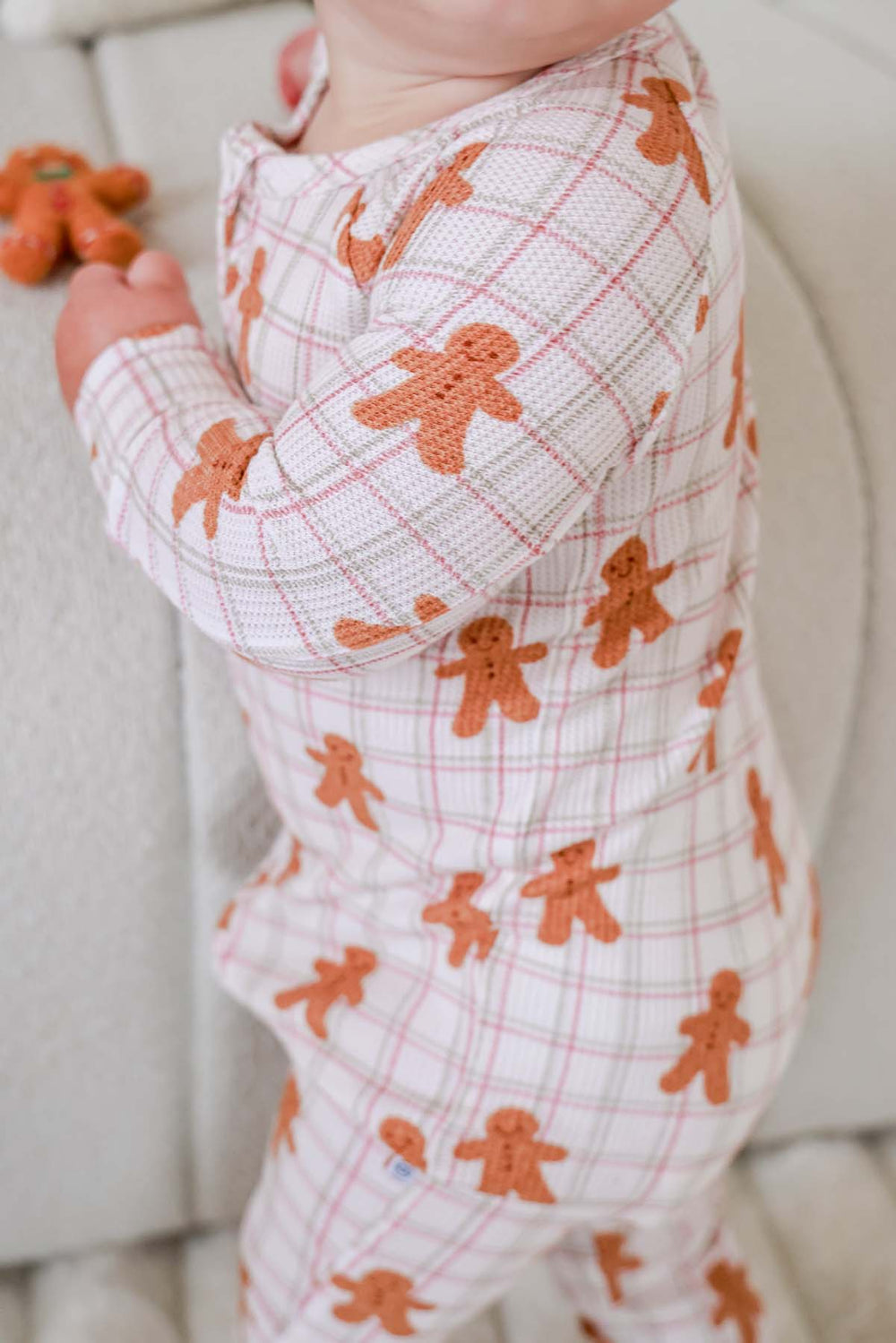 Caden Lane close-up of a toddler wearing a soft bamboo waffle zipper romper in a gingerbread cookie plaid print, highlighting the cozy texture, festive holiday design, and comfortable fit.