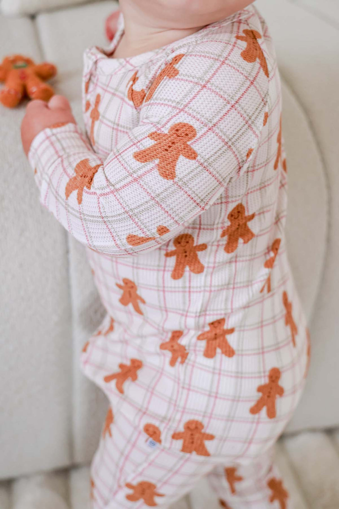 Caden Lane close-up of a toddler wearing a soft bamboo waffle zipper romper in a gingerbread cookie plaid print, highlighting the cozy texture, festive holiday design, and comfortable fit.