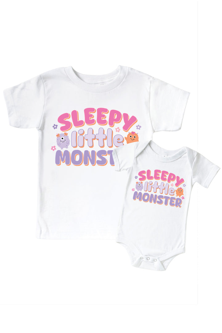 Caden Lane matching white "Sleepy Little Monster" t-shirt and onesie set with pink, purple, and orange monster graphic and floral accents