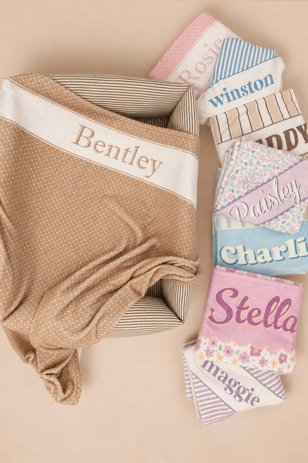Collection of personalized pet blankets in various patterns and colors fanned out, with the latte polka dot 'Bentley' blanket in front