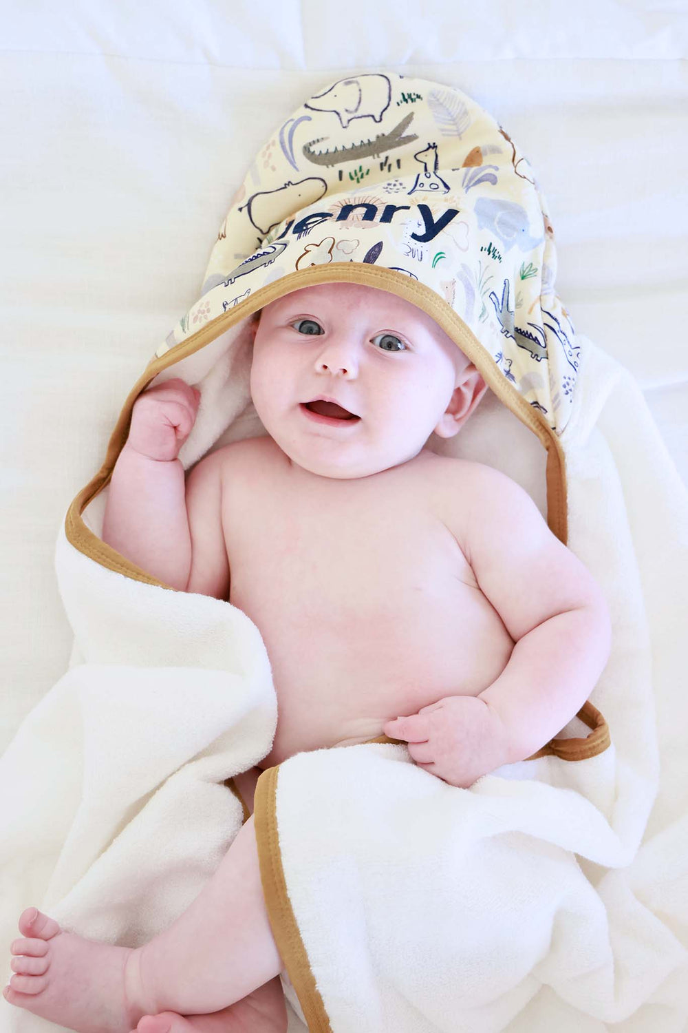 baby boy wrapped in embroidered hooded towel in into the wild print 