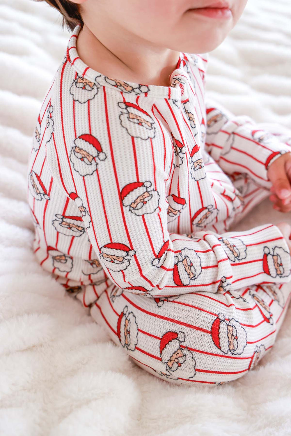 Close-up of the Caden Lane Holly & Jolly Bamboo Waffle Convertible Zipper Romper in a vintage Santa print, made from soft bamboo viscose waffle knit with a two-way zipper for cozy Christmas baby sleepwear.