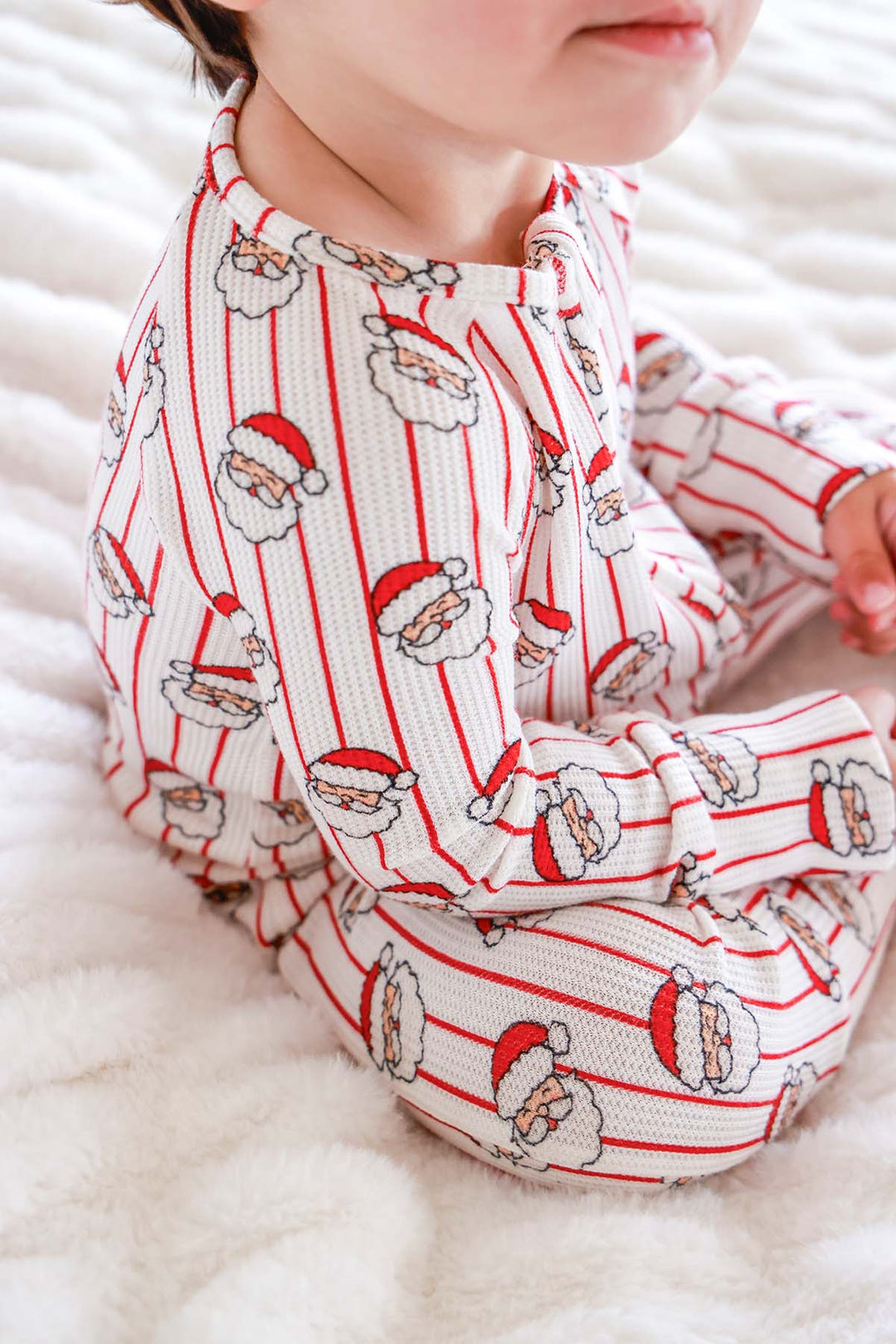 Close-up of the Caden Lane Holly & Jolly Bamboo Waffle Convertible Zipper Romper in a vintage Santa print, made from soft bamboo viscose waffle knit with a two-way zipper for cozy Christmas baby sleepwear.