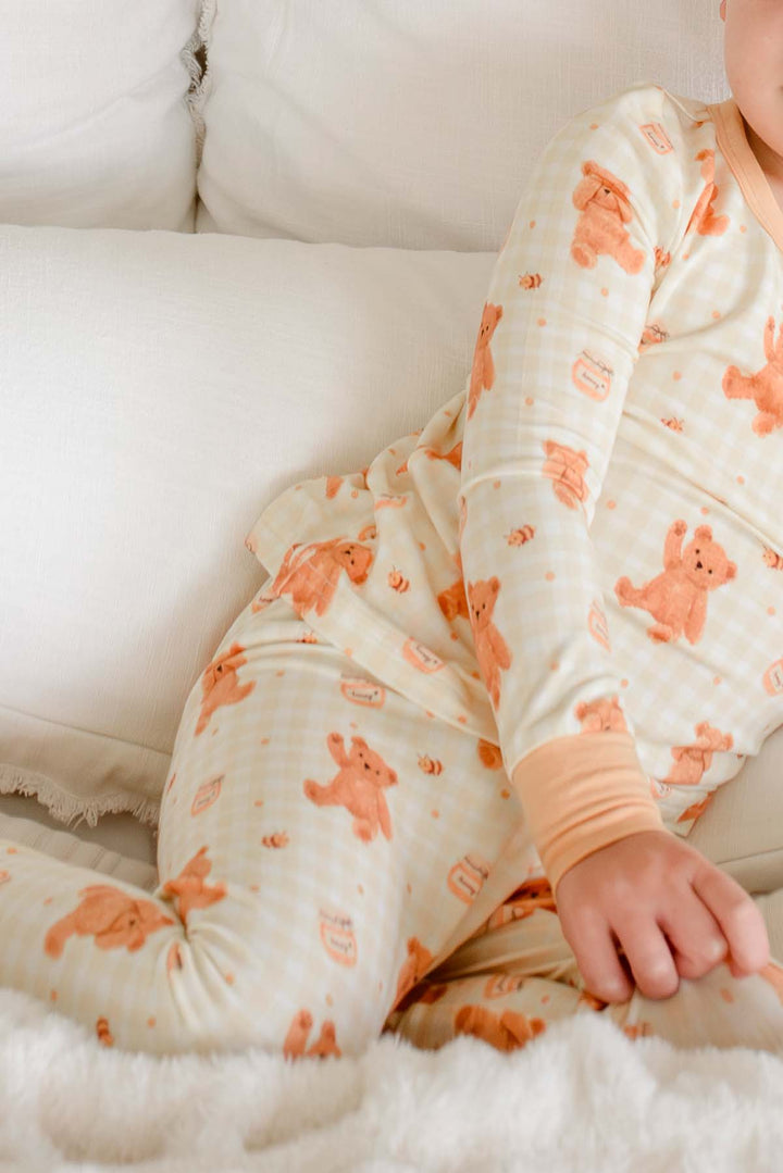 Toddler wearing a Caden Lane honey bear print two-piece pajama set