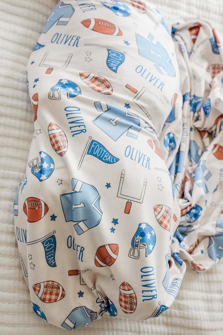 Close up of the Caden Lane huddles and cuddles blue football swaddle. 