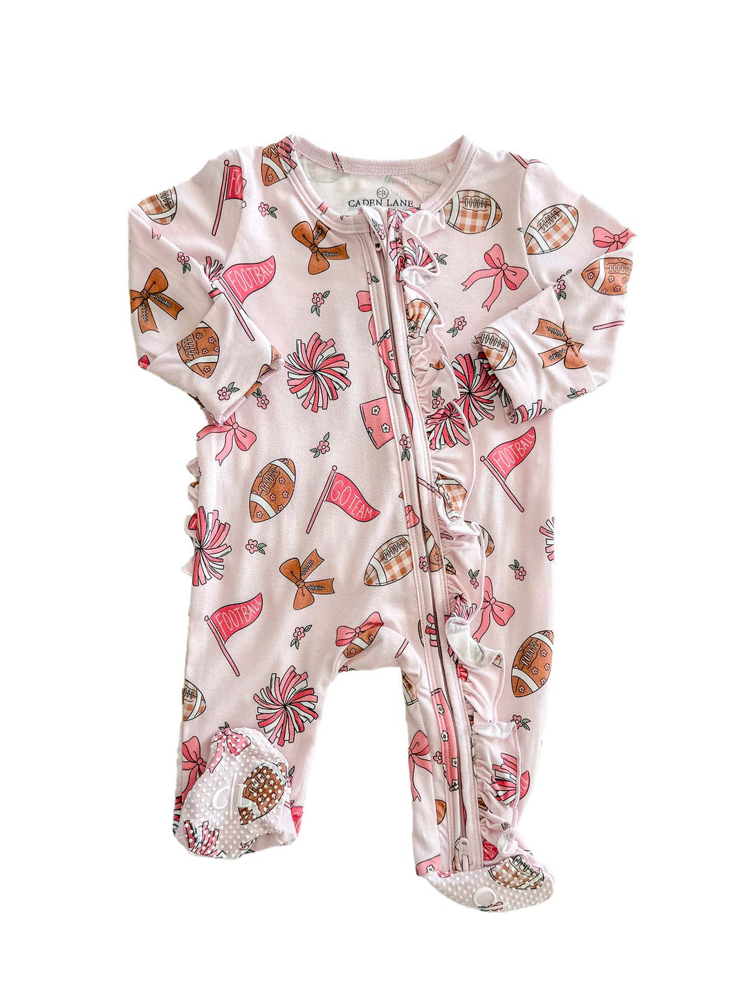 A baby footed sleeper in a light pink color with an all-over print of footballs, flags, bows, and plaid patterns, shown against a plain white background.