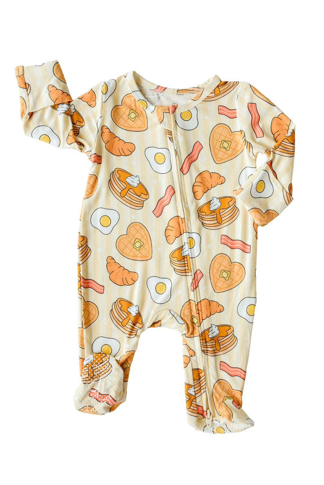 Flat lay of Caden Lane's "I Love You Brunch" print zip-up pajamas, featuring waffles, eggs, bacon, and croissants.
