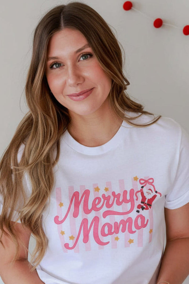 Woman wearing the Caden Lane Women's Merry Mama Graphic Tee from the Holly Jolly Christmas Collection, featuring a festive pink holiday graphic with Santa and ribbon bows.