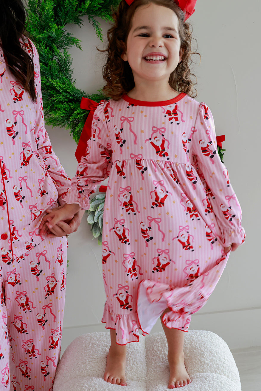 Girl wearing the Caden Lane Jolly Ribbons Long Sleeve Christmas Nightgown alongside matching family pajamas for festive holiday memories.