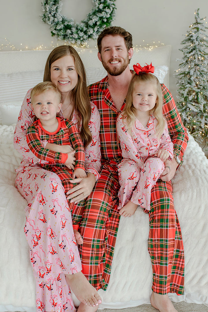 Family wearing matching Caden Lane Christmas pajamas, including the Jolly Ribbons bamboo pajama sets,  and the Plaid Tidings pajama sets, gathered together for a festive holiday family portrait.