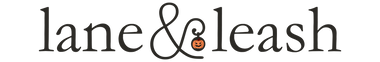 Lane & Leash Halloween themed logo. Text in black reading "lane&leash" with a pumpkin in the middle.