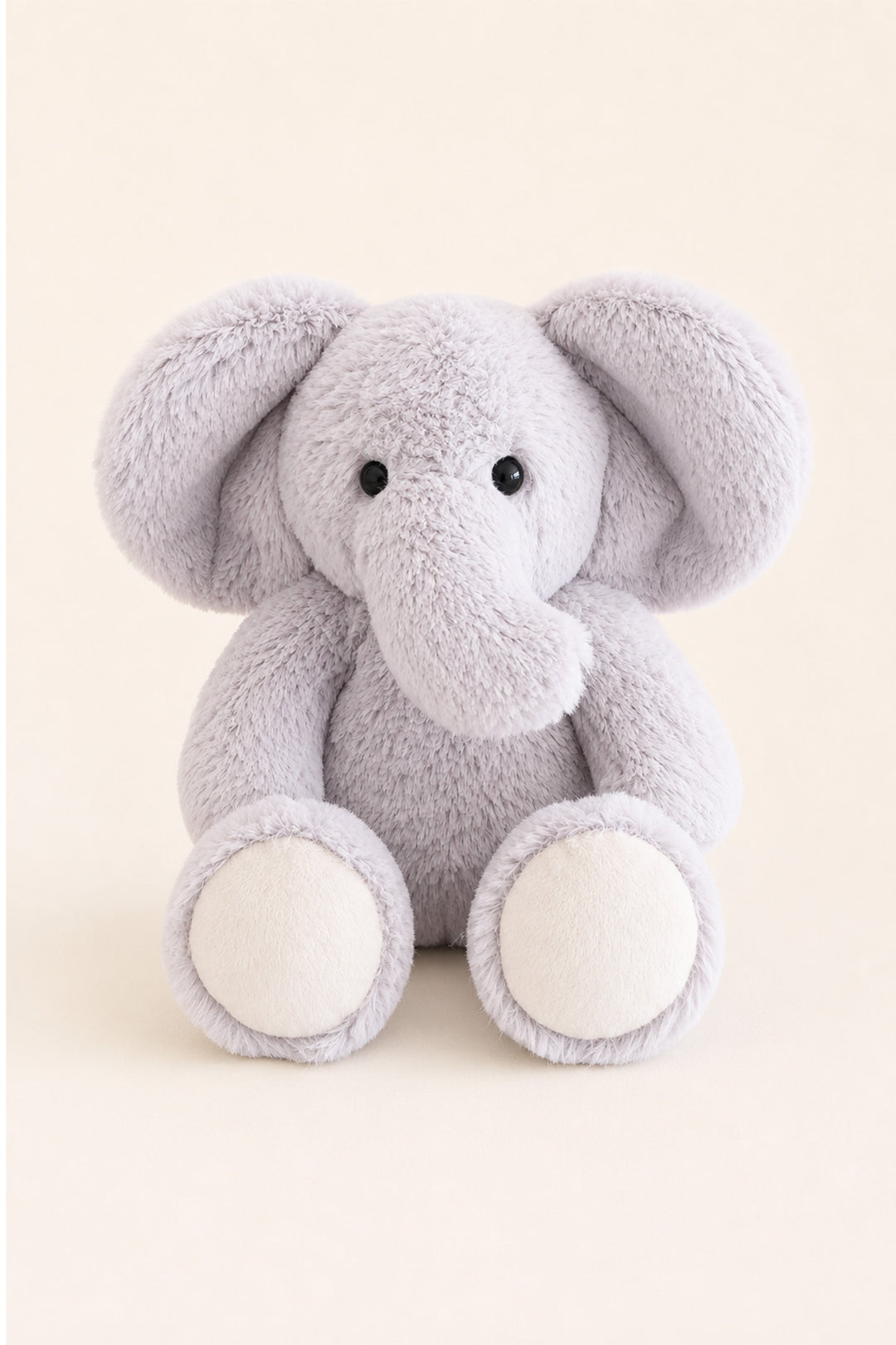 A lCaden Lane light gray plush elephant toy with large floppy ears, a soft trunk, and cream-colored feet, centered against a warm beige background.