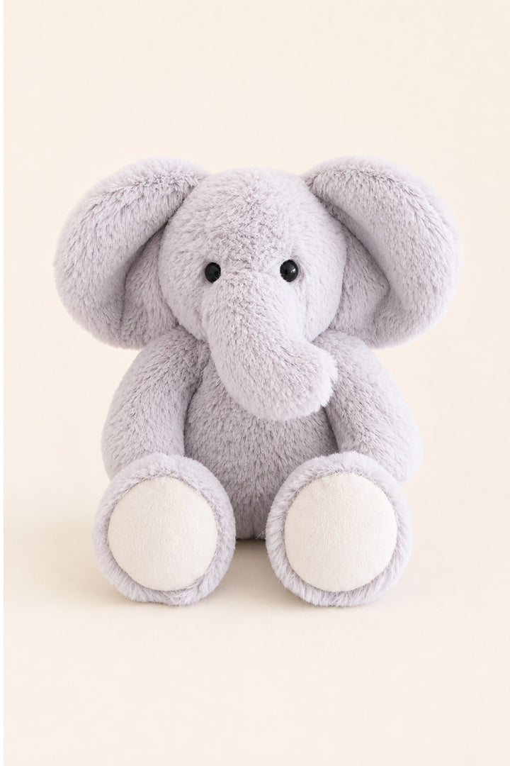 A lCaden Lane light gray plush elephant toy with large floppy ears, a soft trunk, and cream-colored feet, centered against a warm beige background.