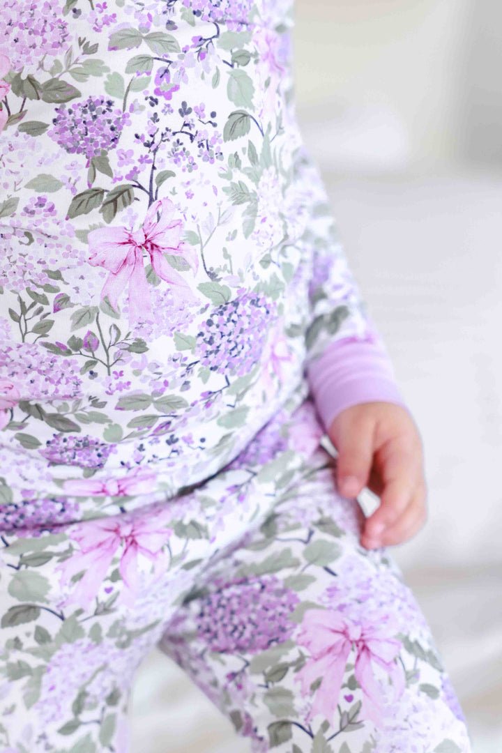 closeup of lavender lullaby print with purple hydrangea and pink ribbon bows