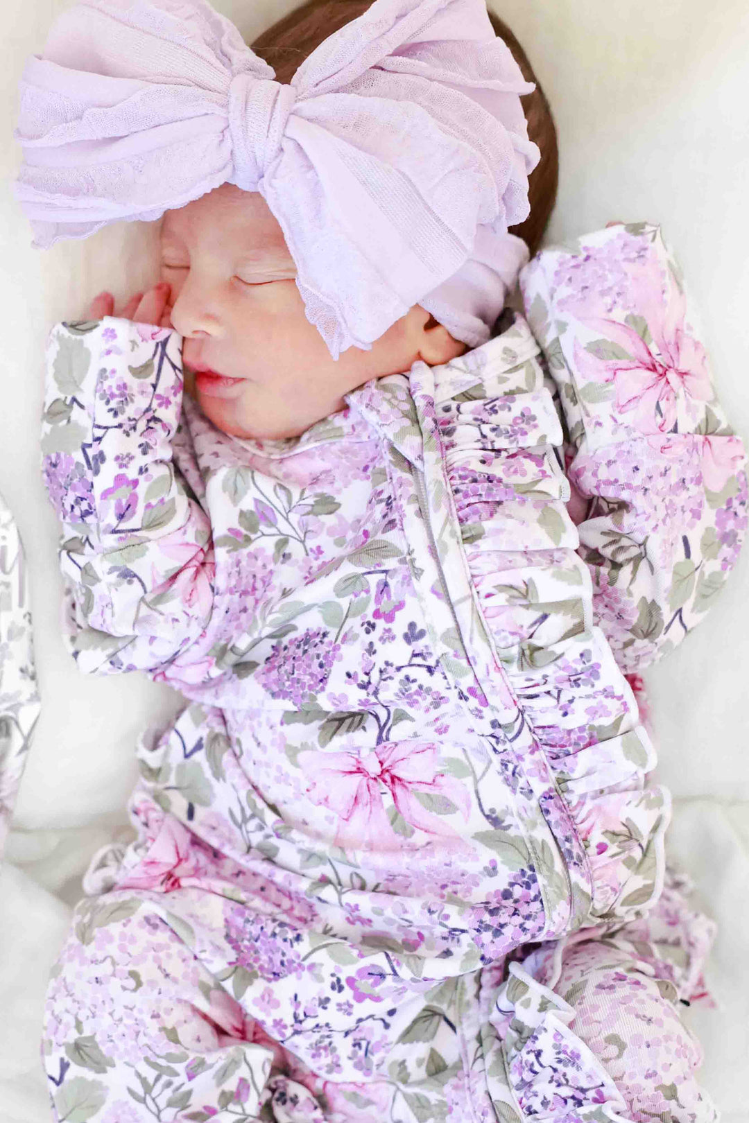 closeup of lavender lullaby print of ruffle zipper footie pajama