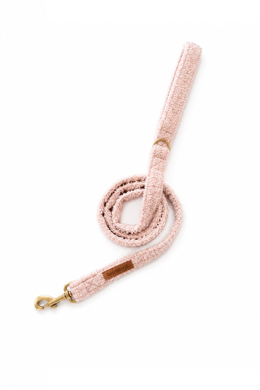 A Lane & Leash light pink textured fabric dog leash with gold-tone metal hardware, including a snap hook and a small leather patch, shown on a plain white background.