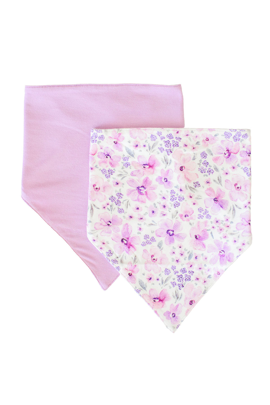 Flat lay of a Caden Lane white knit bandana bib in a Lilac Dreams print featuring pink and purple watercolor flowers, paired with a solid lilac bandana bib.