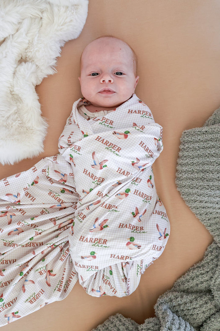 Newborn baby swaddled in personalized little mallard duck print swaddle blanket with repeating name and duck pattern