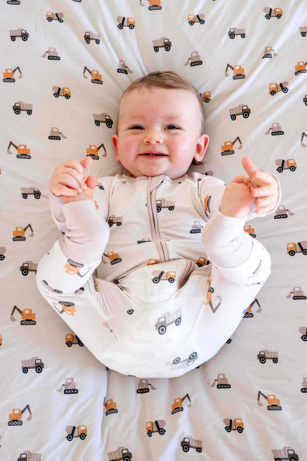 baby boy holding feet in little builder convertible zip romper pajama 