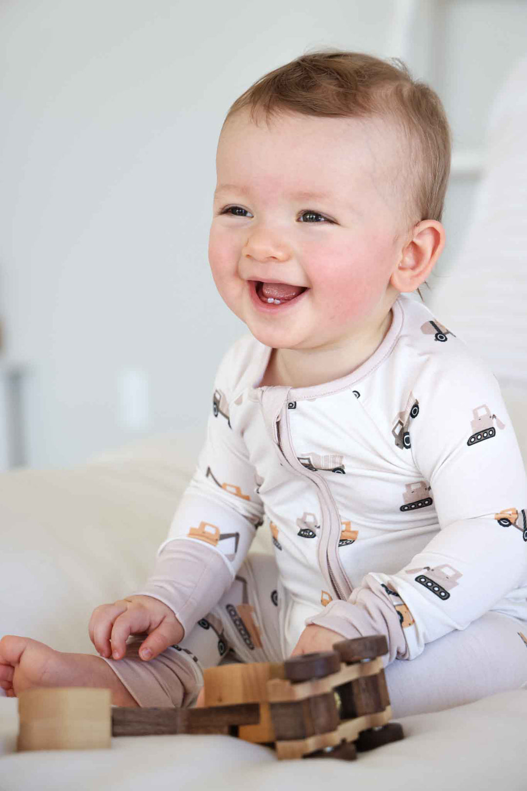 laughing baby boy in little builder convertible zip romper 