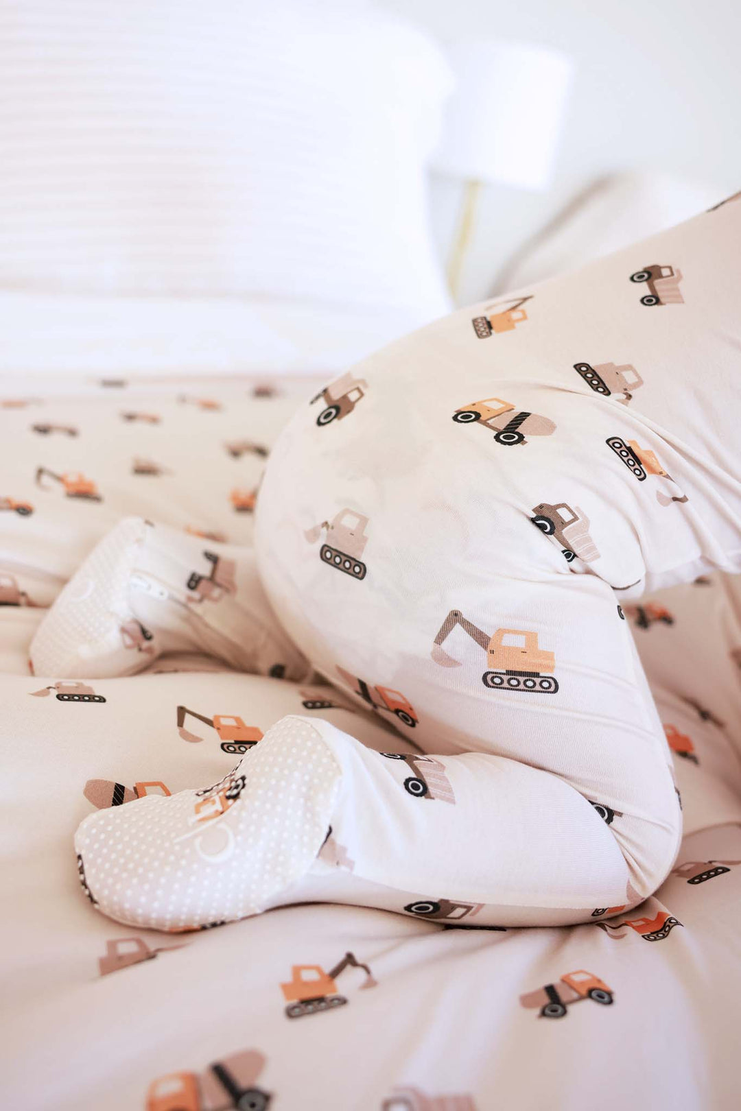 crawling baby wearing the little builder bamboo zipper footie