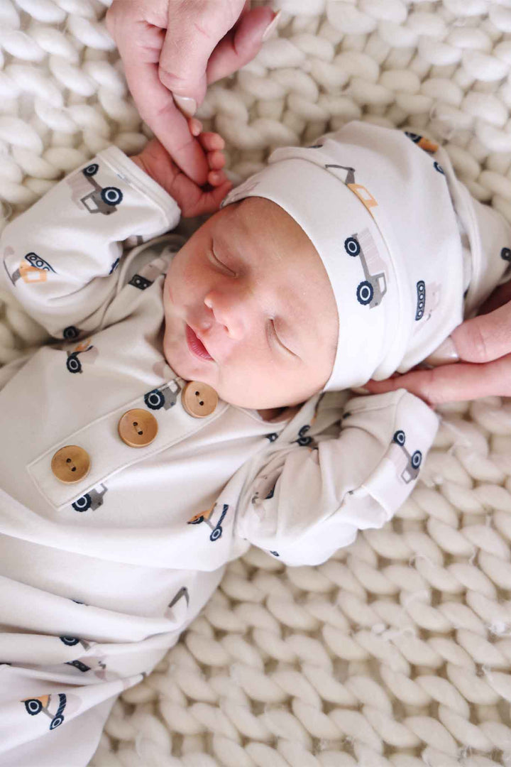 closeup of baby boy sleeping in little builder knot gown 