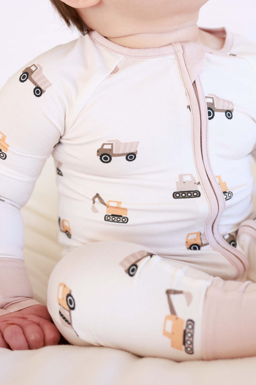 closeup of neutral construction equipment convertible zip romper