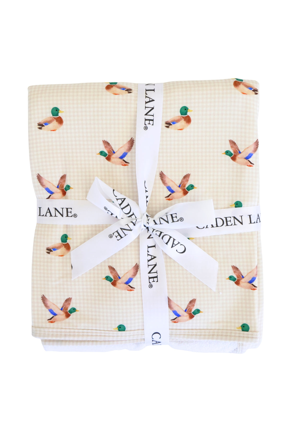 Close-up of folded little mallard duck print bamboo fabric tied with a white Caden Lane ribbon bow, showing vibrant mallard duck pattern