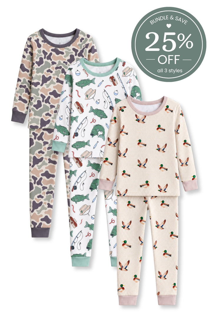 Flat lay of three Caden Lane bamboo two-piece pajama sets in Camo Cutie, Off the Hook, and Little Mallard prints featuring camouflage, fishing gear and bass, and flying mallard ducks.