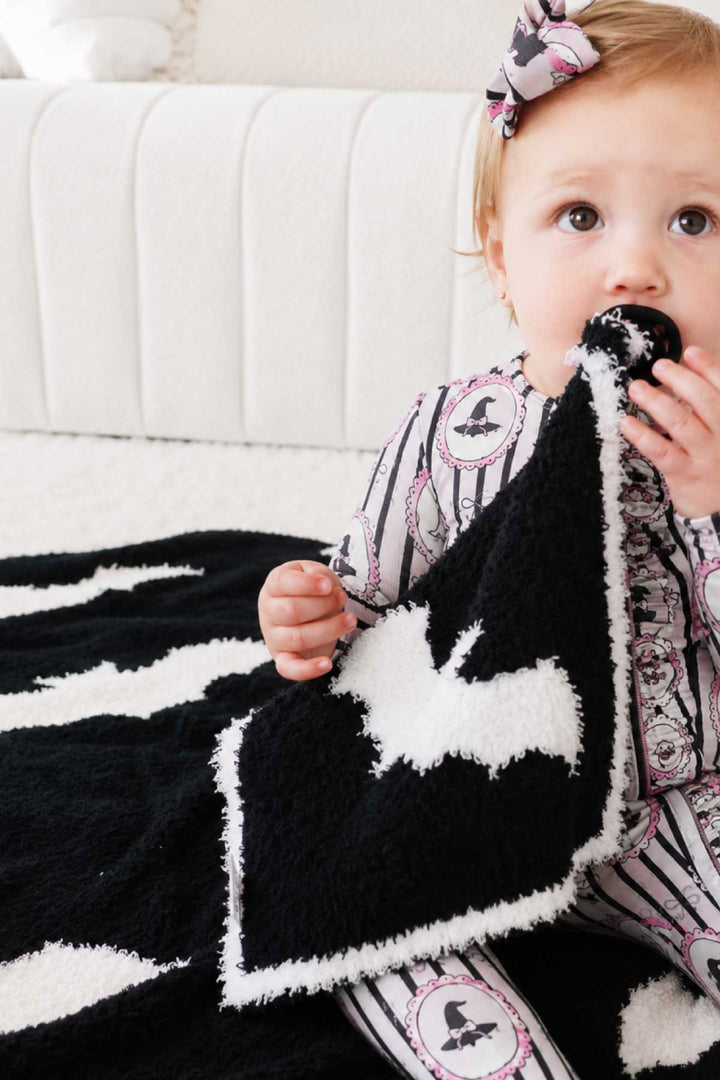 baby girl with reversible bat lovey on pacifier