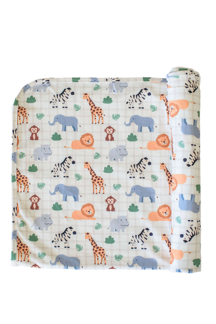 Partially rolled Caden Lane bamboo blanket in a Wild Child print featuring zebras, giraffes, elephants, lions, hippos and monkeys on cream plaid.