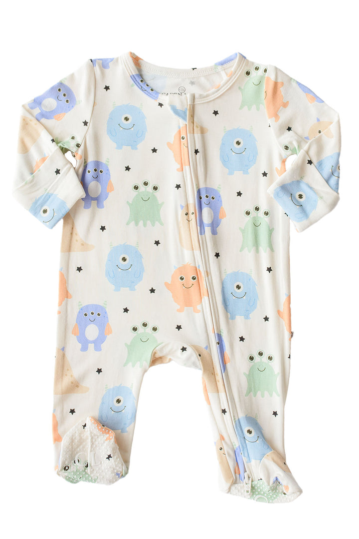 Flat lay of a Caden Lane Little Monsters zipper footie, front view showing blue, green, and orange cartoon monsters on cream fabric