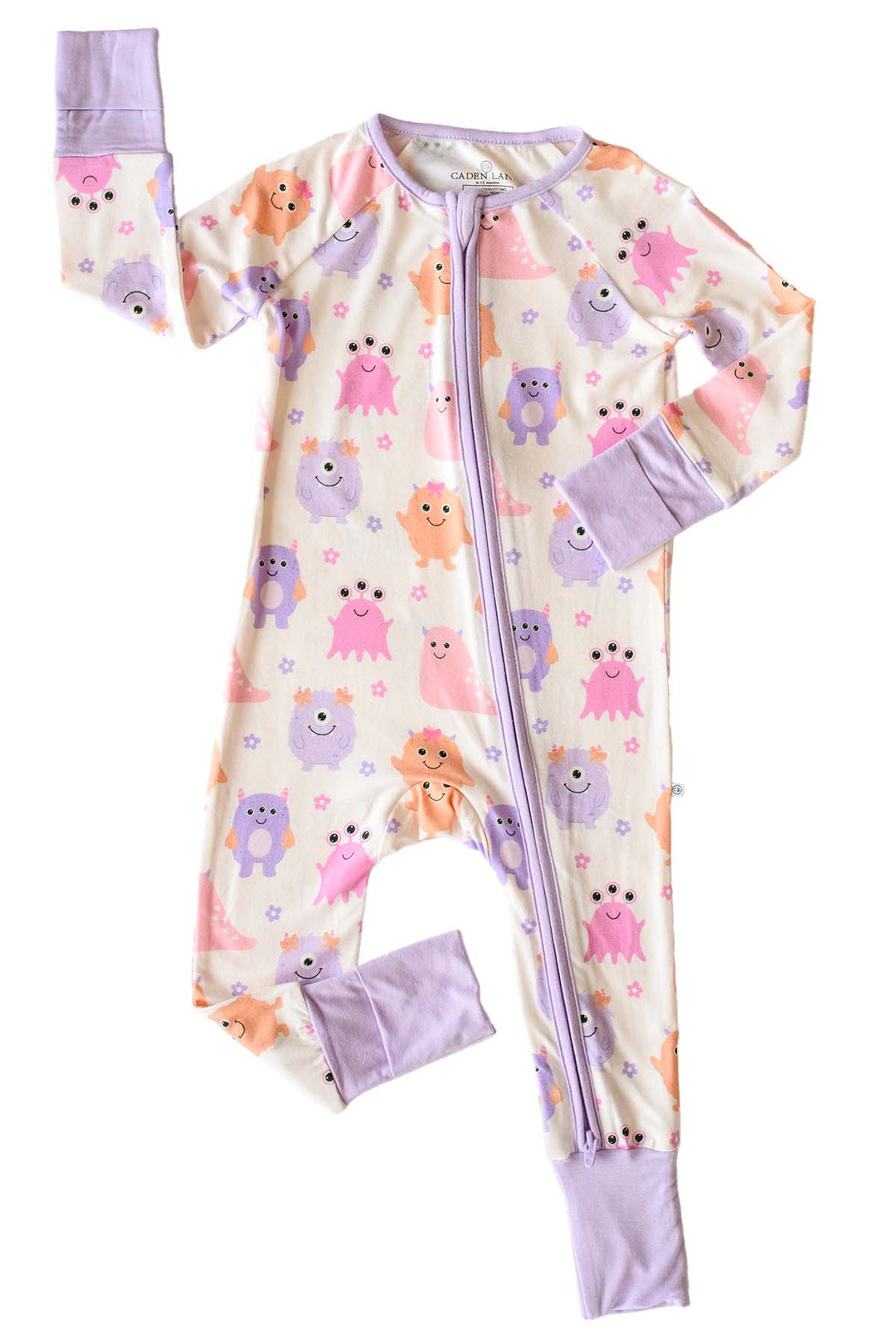 Flat lay of a Caden Lane Little Monsters zipper footie with lavender trim, showing pink, purple, and orange cartoon monsters and floral accents