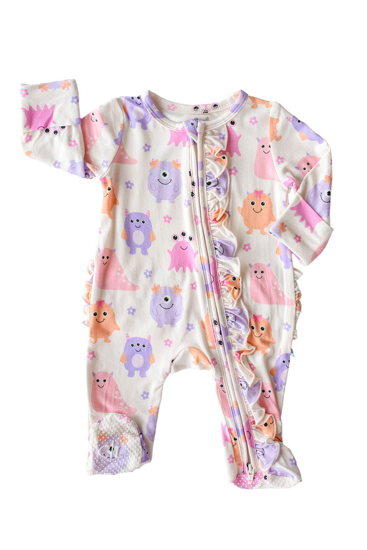 A baby long-sleeve footed sleeper with a front zipper, featuring a playful print of colorful cartoon monsters on a cream-colored background.