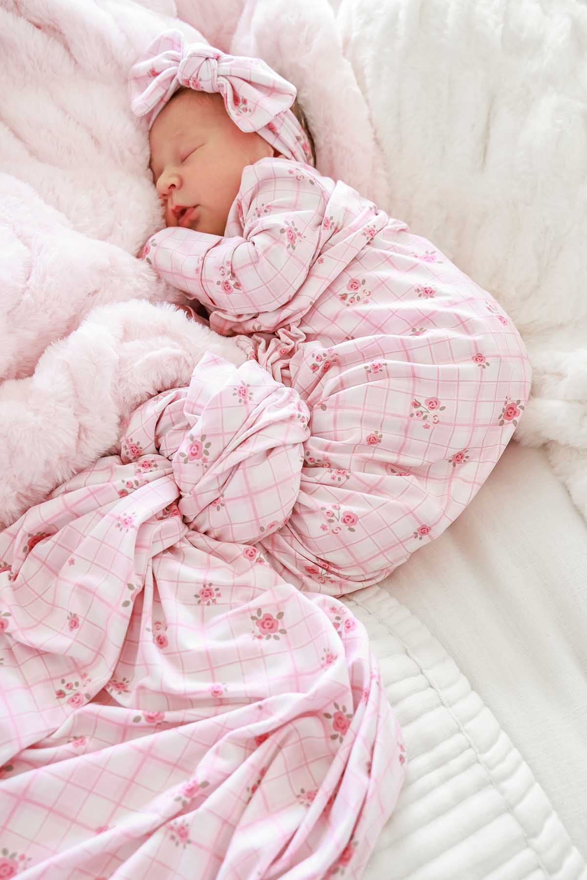 Newborn swaddled in oversized Primrose Plaid blanket with bow headwrap