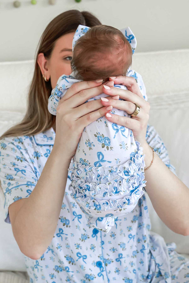 mom holding baby with back to camera in tied in blooms ruffle footie
