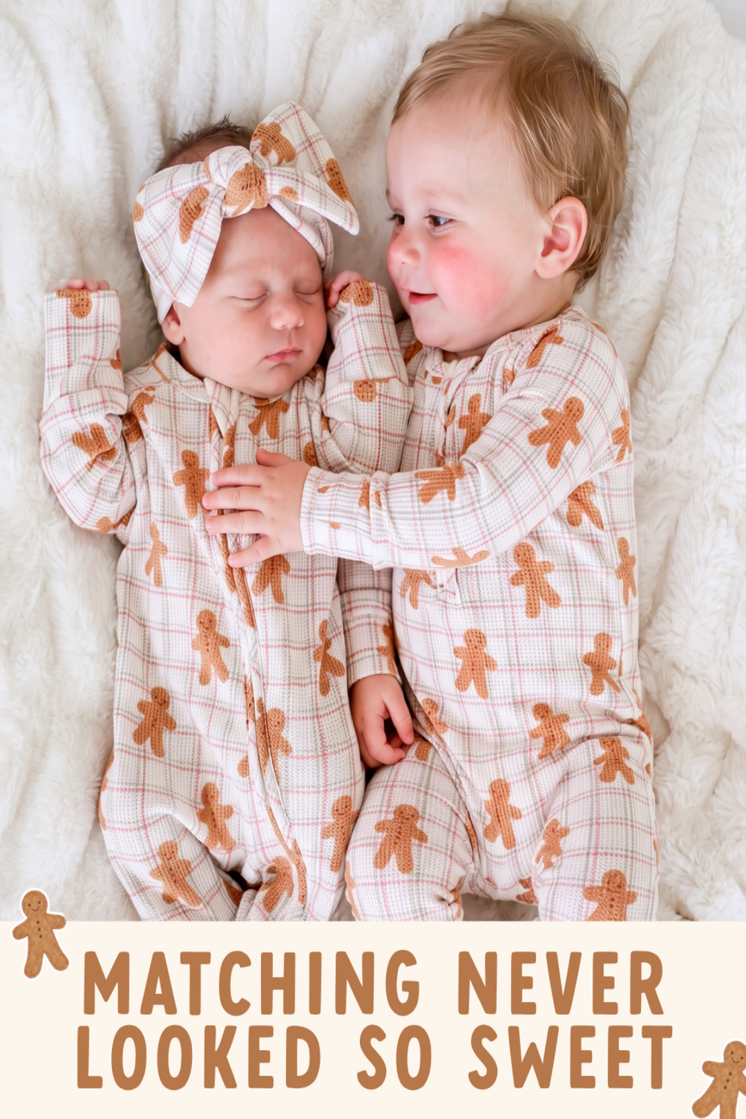 A baby and toddler wearing matching gingerbread-themed footed onesies and a matching headband, lying side by side on a soft white blanket. The text overlay at the bottom reads 'MATCHING NEVER LOOKED SO SWEET'.