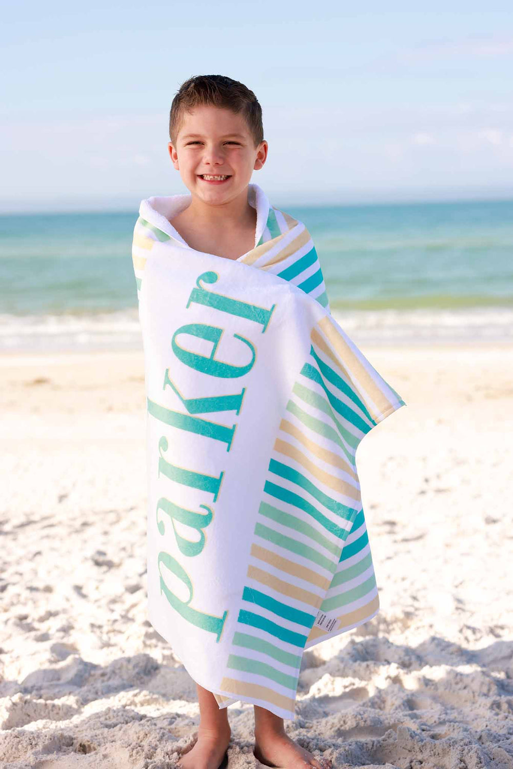 boy at the beach wrapped in seersucker personalized towel