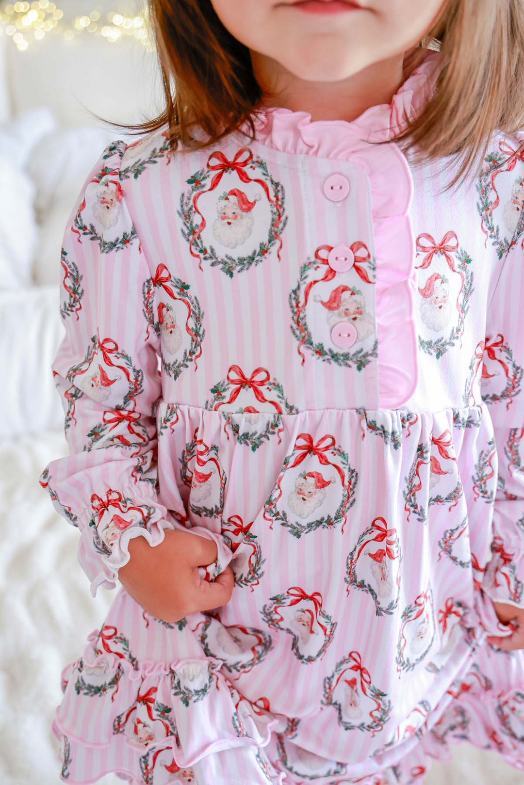Close-up of a Caden Lane pink striped nightgown featuring vintage Santa portraits in holly wreaths with a ruffled button placket