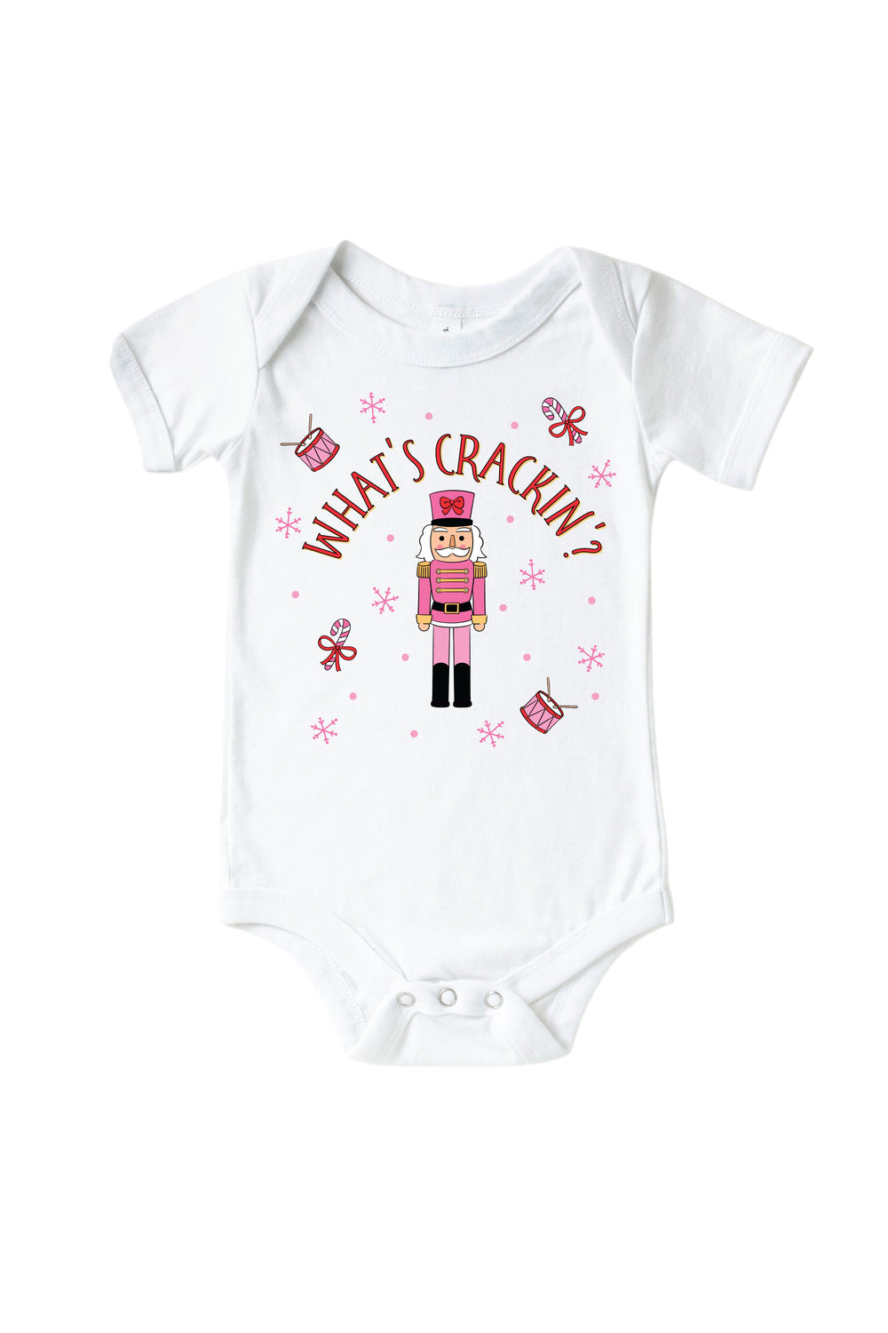 Caden Lane's white "What's Crackin'" baby onesie featuring a pink toy soldier nutcracker with snowflakes, candy canes, and drums, laid flat.