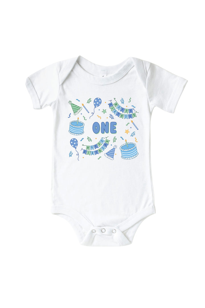 Caden Lane Birthday Bash white baby bodysuit with "ONE" printed in blue bubble letters, surrounded by cake and party hat print in blue and green.
