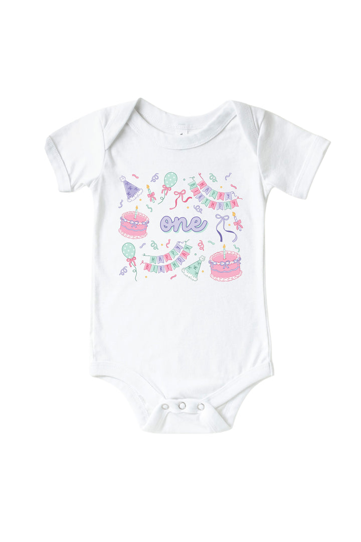 Caden Lane Birthday Bash white baby bodysuit with "one" in purple script, surrounded by cake and party hat print in pink and mint.