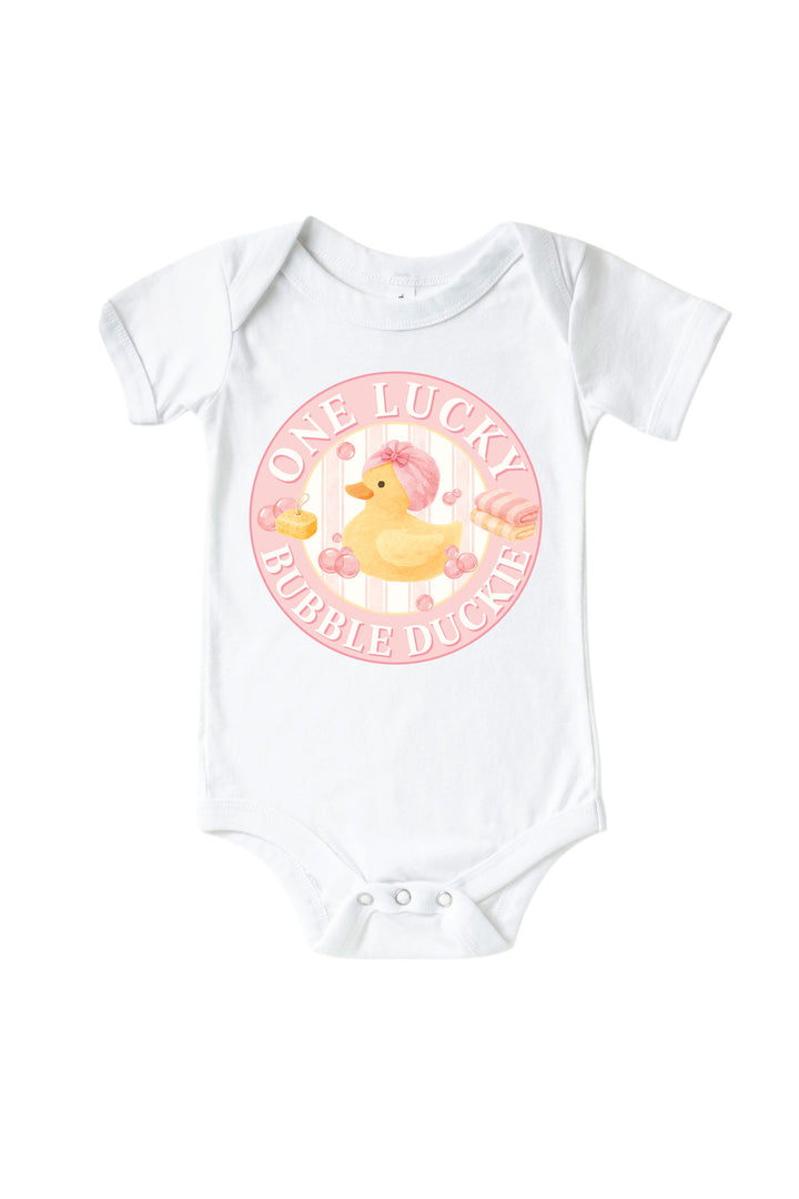 White baby bodysuit with pink circle One Lucky Bubble Duckie graphic featuring yellow rubber duck with pink bow and bubbles on front