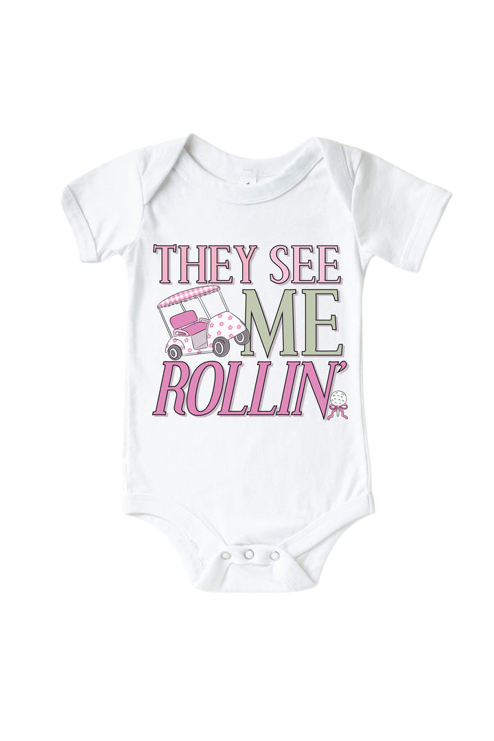 pink they see me rollin' golf graphic bodysuit in white, caddie crew, flat lay