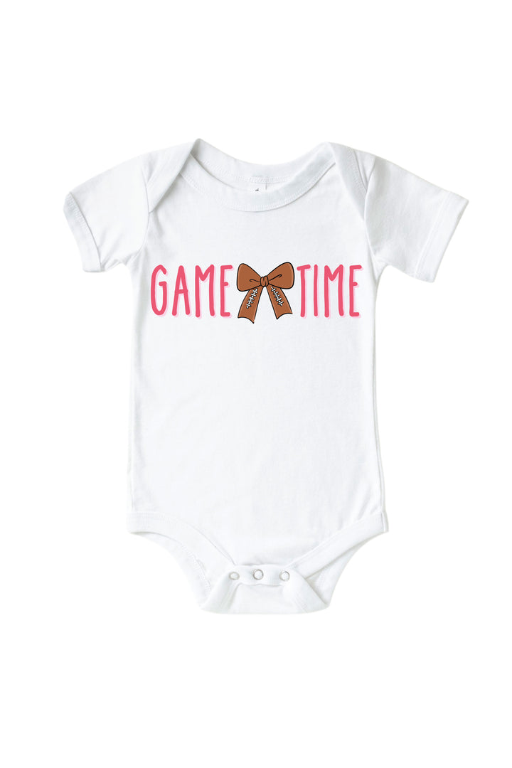 Caden Lane Graphic Bodysuit & Kids' Tee, Game Time Pink — baby bodysuit in white with "Game Time" graphic, featuring a football-patterned bow