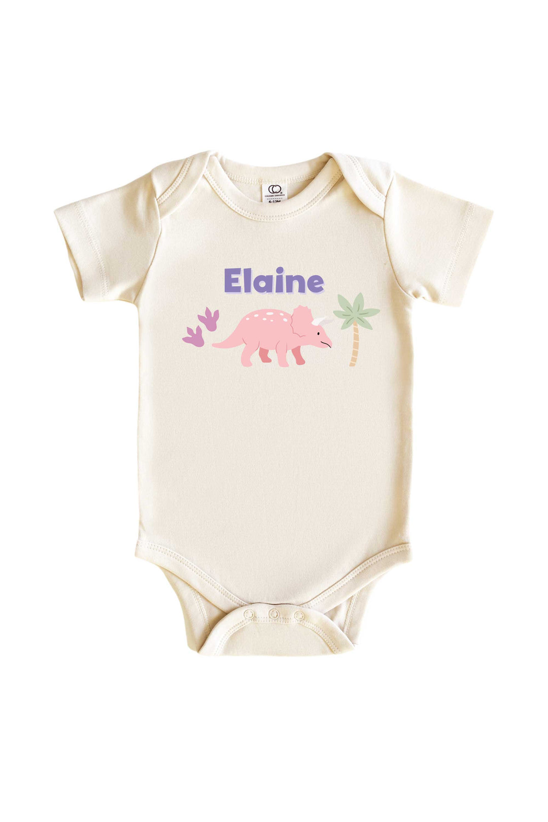 Natural cream baby bodysuit with personalized name in purple lettering and a pink triceratops dinosaur graphic with pastel plant accents