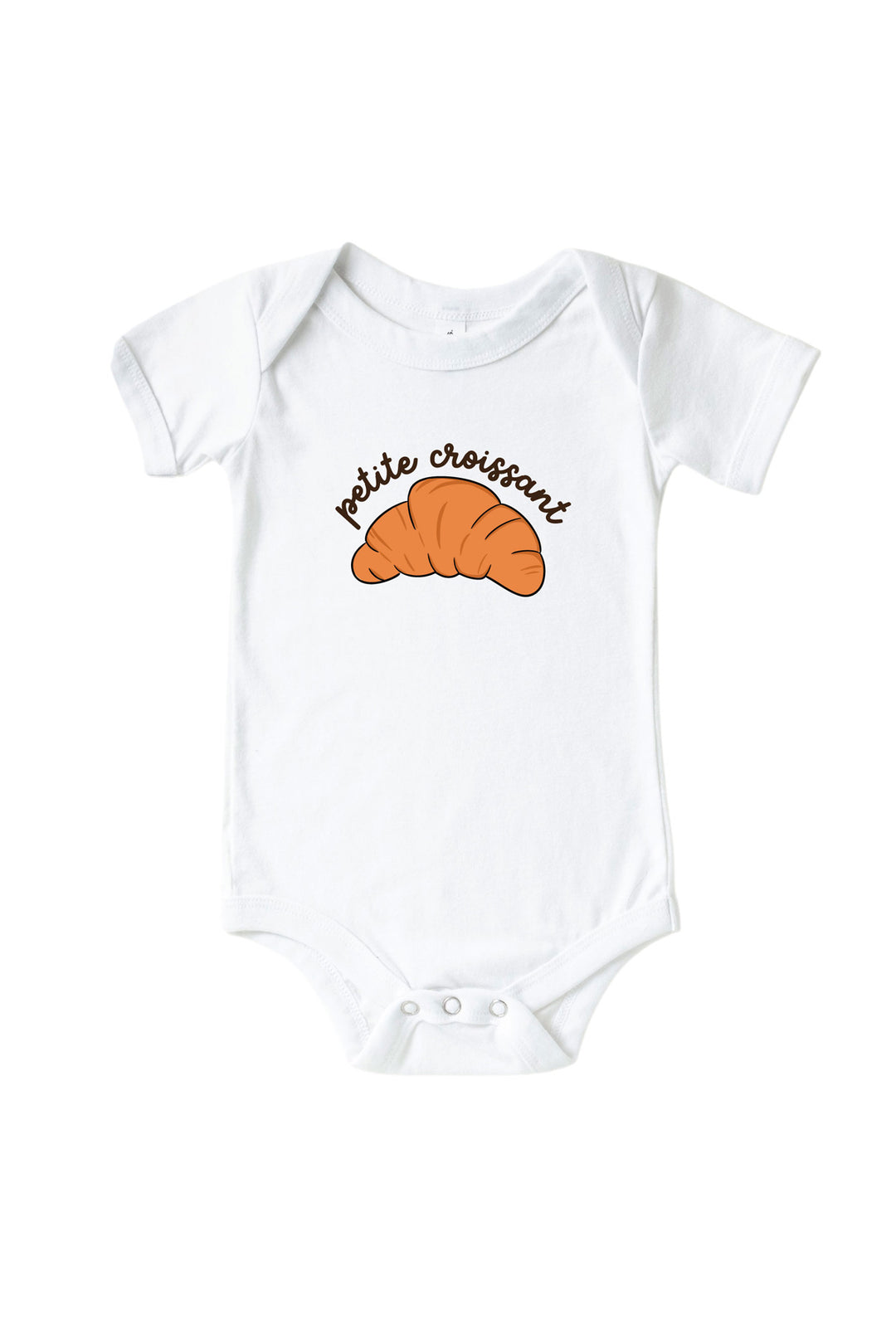 A white Caden Lane short-sleeve baby bodysuit featuring a graphic of an orange croissant with the text 'petite croissant' in black script above it, displayed on a clean white background.