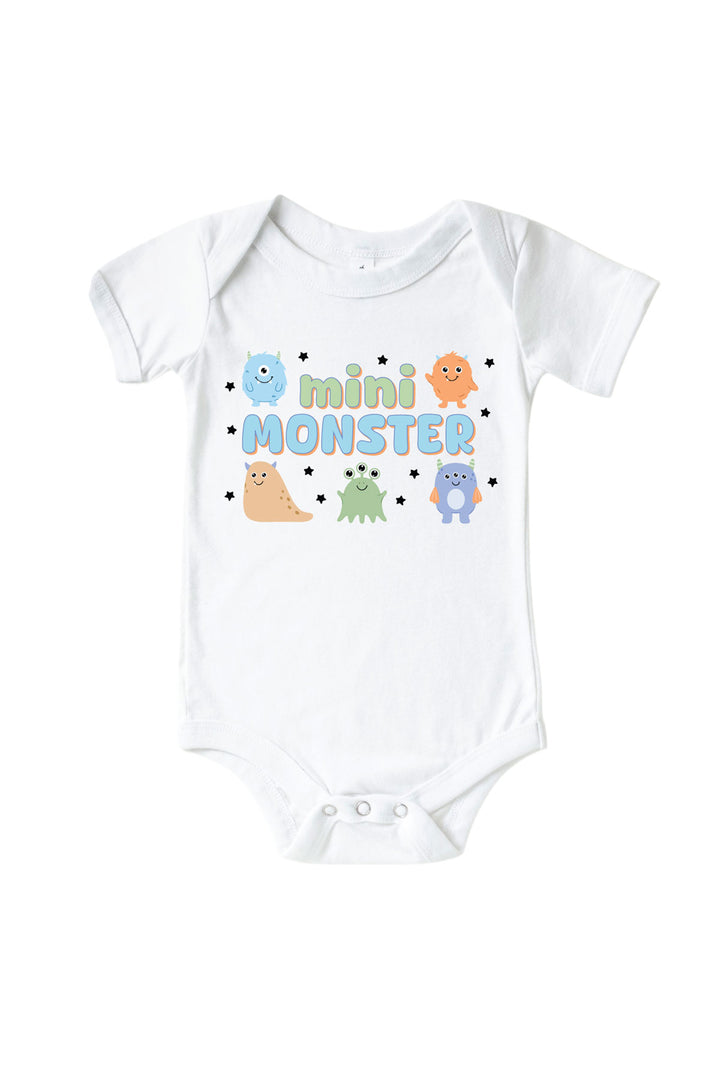 Caden Lane white baby onesie with "Mini Monster" graphic in green and blue lettering, featuring blue, orange, tan, green, and purple cartoon monsters and stars