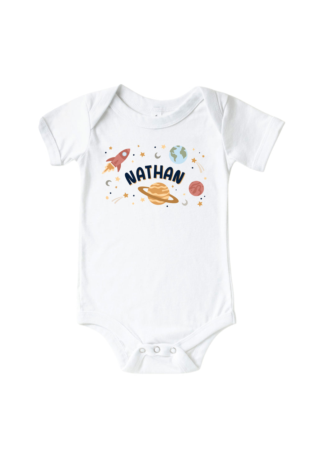 Flat lay of a Caden Lane white short-sleeve bodysuit with a Stellar Snuggles Planets graphic featuring labeled planets, two rockets, and scattered stars.