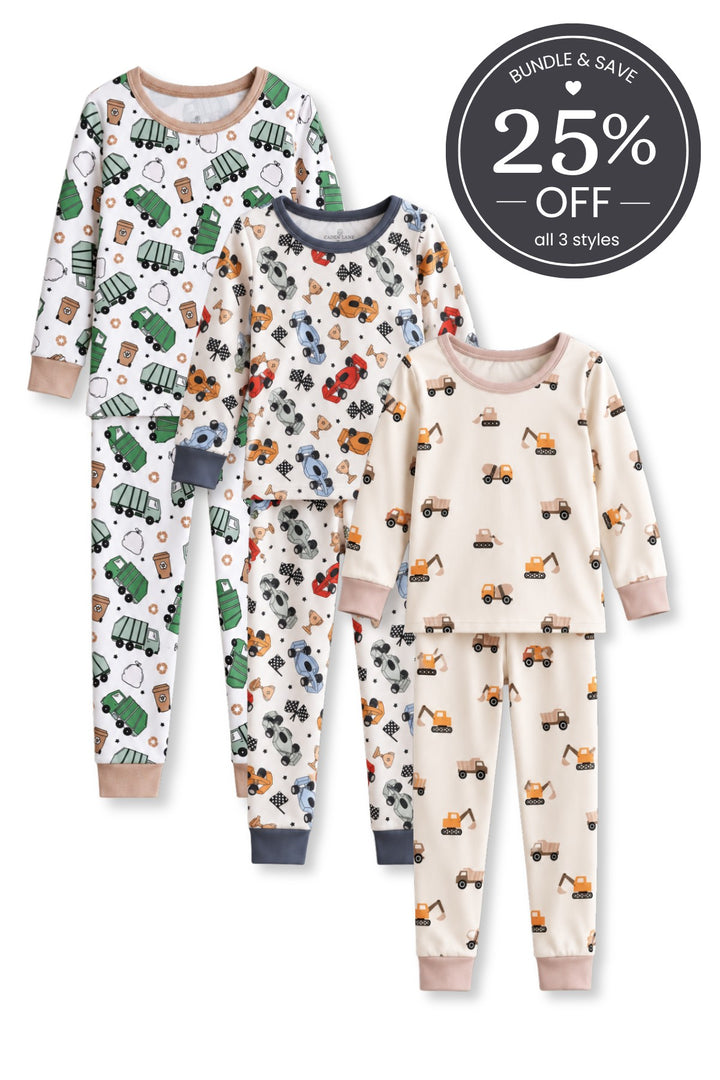 Flat lay of three Caden Lane two-piece pajama sets in garbage truck, race car, and construction vehicle prints.